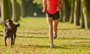 Woman running in the park with a dog